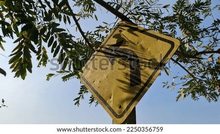 yellow square traffic sign there is a black curved arrow Warning to be careful of the curved road ahead. 