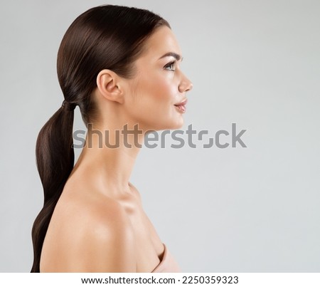 Beauty Model Perfect Face Profile. Brunette Woman with Healthy Smooth Facial Skin and Hair over White. Beautiful Girl Side view Portrait with Full Lips and Natural Make up. Female Plastic Surgery