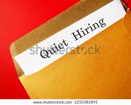 Office envelope with text document QUIET HIRING - HR buzz word of recruiting strategy, employees who stand out by going above and beyond get more attention, money, praise, and more opportunities Royalty-Free Stock Photo #2250382895