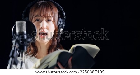 A woman reading a script. Voice actress. Narrator. Royalty-Free Stock Photo #2250387105
