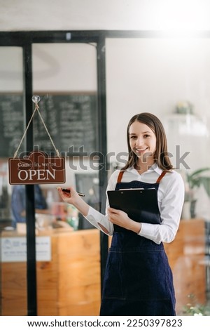 Startup successful small business owner sme woman stand with tablet and notepad in cafe restaurant. woman barista cafe owner. 
