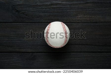 Baseball ball on black wooden table, top view. Sports game