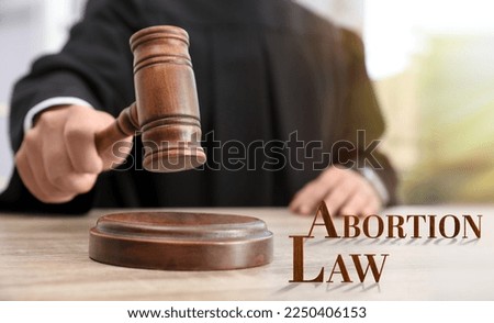 Abortion law. Judge with gavel at wooden table, closeup Royalty-Free Stock Photo #2250406153