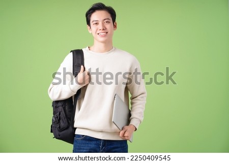 Image of young Asian student on background Royalty-Free Stock Photo #2250409545