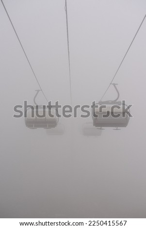 Amusement park rides, excursion with ski lift in the fog. Natural park background, abstract scenic landscape in mountains. Vacation trip ideas Royalty-Free Stock Photo #2250415567