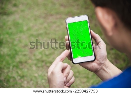 Man seriously looking at mobile phone with broken cracked screen display need to be fixed, mobile repair shop concept