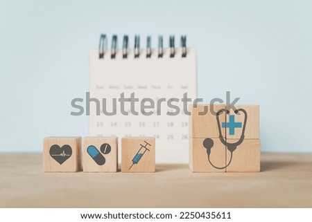 For medical healthcare, health insurance concept. medical and health icon on wooden cube block with blurred calendar