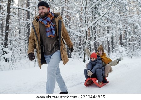 Dad sledding his family in the park