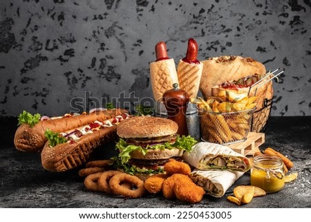 take away fast food products Kebab, pita, gyros, shaurma, wrap sandwich with french fries and nuggets meal, junk food and unhealthy food. banner, menu, recipe place for text. Royalty-Free Stock Photo #2250453005