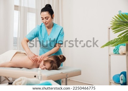 therapeutic massage of the woman's back in the parlor Royalty-Free Stock Photo #2250466775
