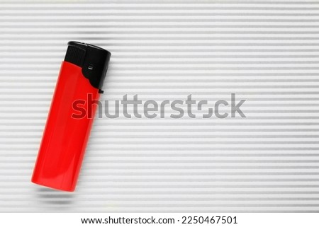 Stylish small pocket lighter on white corrugated fiberboard, top view. Space for text