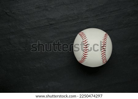 Baseball ball on black slate background, top view with space for text. Sports game