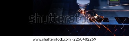 Industrial laser cut machine while cutting the sheet metal with the sparking light.copy space	 Royalty-Free Stock Photo #2250482269