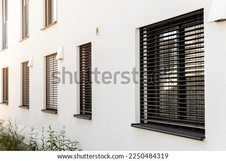 Roller Blinds on Windows of Modern House. Window with Shutter Outside.  Royalty-Free Stock Photo #2250484319