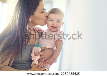Mother, bonding and forehead kiss for baby girl on in house living room, nursery or family home bedroom in trust or love. Smile, happy and infant child with mom in support, security or safety comfort