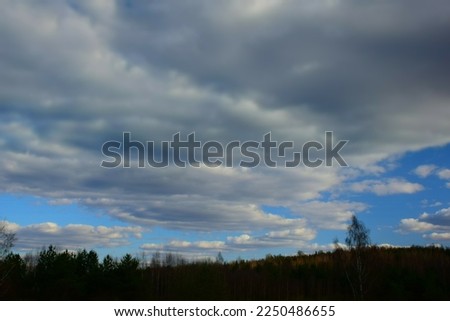 Dramatic stormy  cloudy sky over green fields. Stock Photo