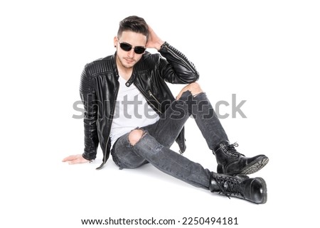 bad boy with sunglasses and hand to head sit on floor isolated in white Studio Royalty-Free Stock Photo #2250494181