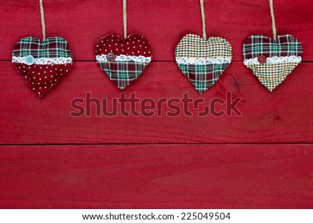 Antique rustic red wooden Christmas background with red and green holiday country hearts border; blank holiday sign with Valentines Day, family and home concept and painted copy space
