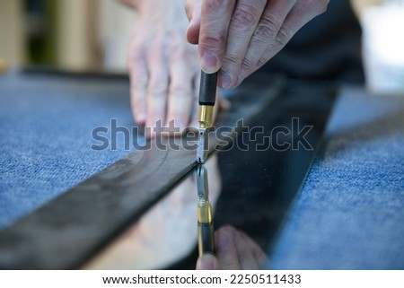 glazier cuts the mirror with a diamond knife Royalty-Free Stock Photo #2250511433
