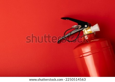 Fire extinguisher on the background of a red wall. Fire protection, home fire extinguisher. home security concept. Place for text. Copy space.