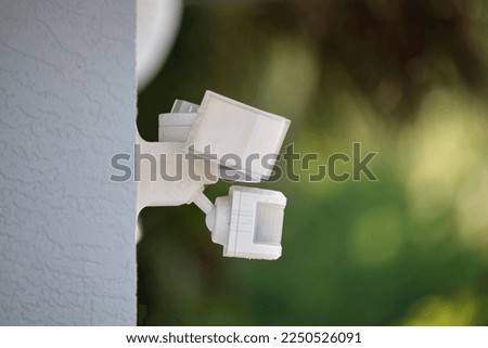 Motion sensor with light detector mounted on exterior wall of private house as part of security system Royalty-Free Stock Photo #2250526091