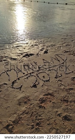 Writing by seashells the name of Thailand country and 2022th year on the sands. Perfect for post cards and wallpapers.
