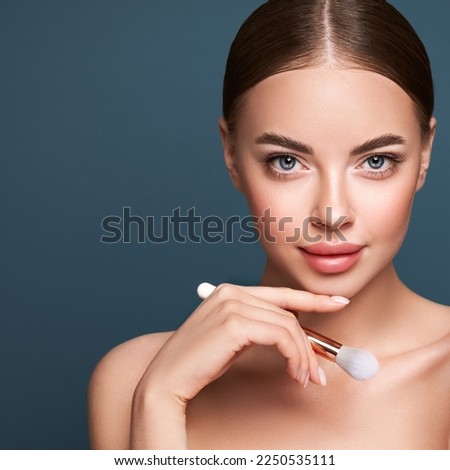 Portrait beautiful young woman with clean fresh skin. Model with cosmetic makeup brush. Cosmetology, beauty and spa