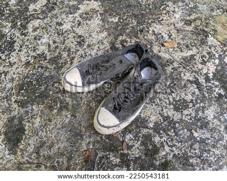 old, unused shoes on the cement floor.