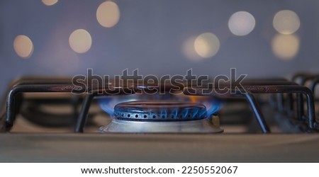The energy crisis. A natural gas stove burning on methane gas. Home kitchen stove with a large blue fire. Fuel economy