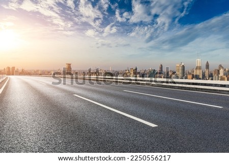 Asphalt road and city skyline with modern buildings at sunrise in Shanghai, China.