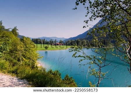 Stunning view of Achen lake, Achensee, Tirol Austria. Amazing nature, mountains around a green colored lake. Meadows full of grass, blue sky, family holiday in Austria. 