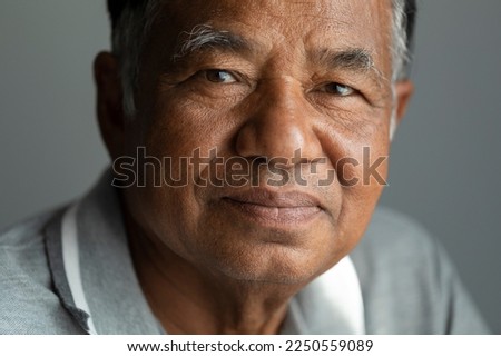 Close-up, old man's face, elderly Asian man thinking and looking at camera in studio. Royalty-Free Stock Photo #2250559089
