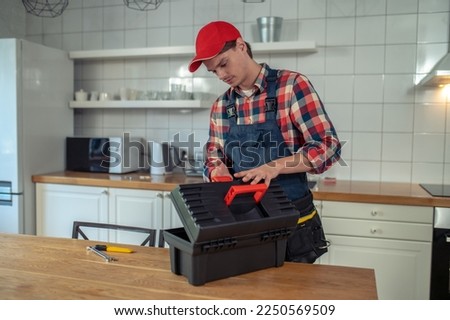 Serviceman focused on preparing for work in a client apartment Royalty-Free Stock Photo #2250569509