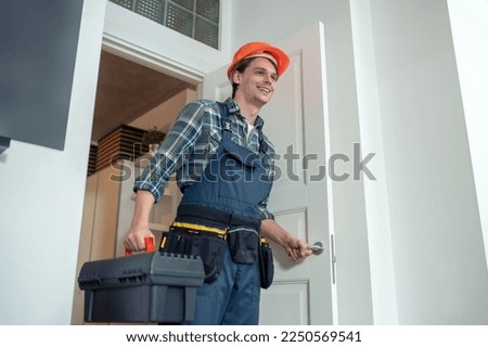 Smiling friendly serviceman arriving at the customer house Royalty-Free Stock Photo #2250569541