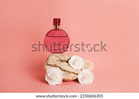 Perfume bottle mockup on pink background. Stone podium and white paper flowers. Natural earthy colors, copy space Royalty-Free Stock Photo #2250606305