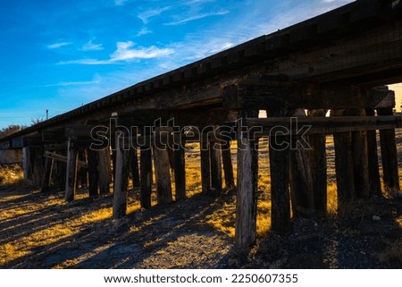 Old Railroad track wooden bridge over Lake Carlsbad Recreation Area next to the Lower Transill Lake of Pecos River in Eddy County, New Mexico, USA, sunset landscape