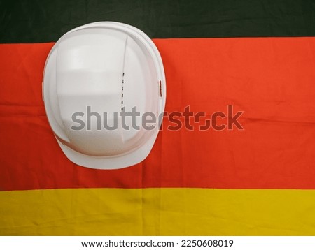 German flag and construction helmet. Concept Made in Germany. German quality.