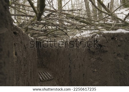 empty infantry trenches covered with tree branches and camouflage netting. protection of soldiers. engineering constructions in the army. hiding the defensive line from enemy aircraft and intelligence Royalty-Free Stock Photo #2250617235