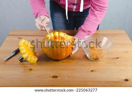 Pictured woman shows how to make a Halloween pumpkin.