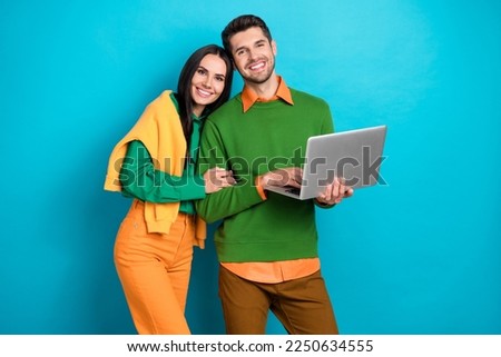 Photo of positive couple using digital netbook search web buy purchase for valentine day isolated on blue color background