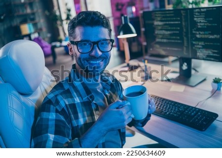Photo of positive professional web designer guy sitting chair hands hold hot tea mug open space workplace indoors