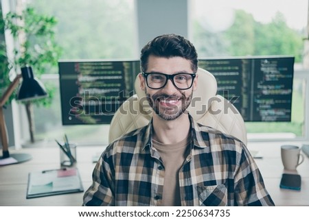 Photo of positive happy freelancer wear eyeglasses smiling creating app software modern gadget indoors workplace workstation loft