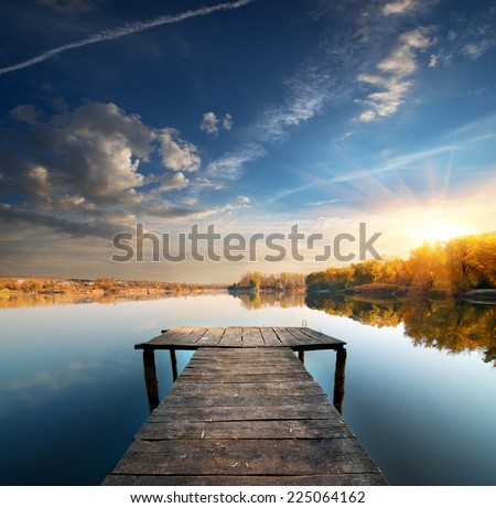 Pier on a calm river in the autumn Royalty-Free Stock Photo #225064162