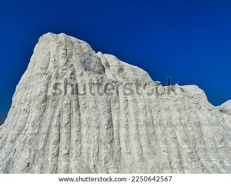 Picture of a big snow covered mountain with blue sky shot during sunlight. White snowy mountain hills, nature, landscape in winter