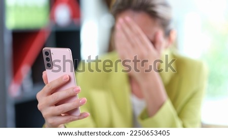 Sad woman covered her face with her hand while reading messages on her mobile phone. Sad and shocking news and tiresome concept. Royalty-Free Stock Photo #2250653405