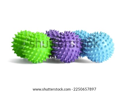 Purple, green and blue double or peanut spiky balls massager for yoga pilates or stretching and fascia pain. Sports equipment for fitness isolated on a white background. Concept of sports massage. Royalty-Free Stock Photo #2250657897