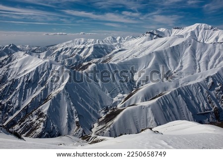 A view of snow-covered mountains in Iran. Horizontal photo of Iran's mountains in winter. Mountain landscape in winter.