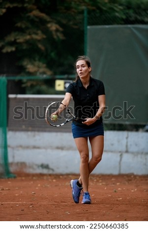 Young beautiful female tennis player with racket and ball prepares to serve at beginning of game or match.