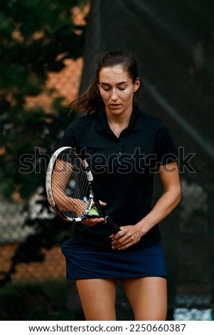 portrait of athletic female tennis player with tennis racket and ball in her hand. Outdoor tennis practice.