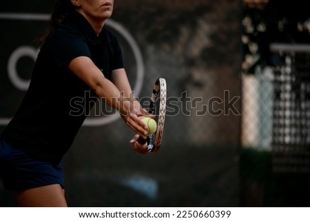 Selective focus on tennis ball and racket. Female tennis player prepares to serve during the match. Sport that requires physical, emotional and mental preparation.